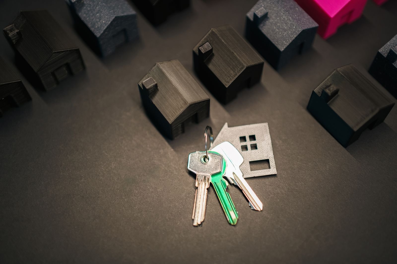 Miniature house models and a key symbolizing real estate decisions